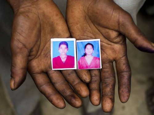 Sohan-55-holds-passport-sized-images-in-his-hands-of-his-daughter-Murti-right-and-niece-Pushpa-500x375