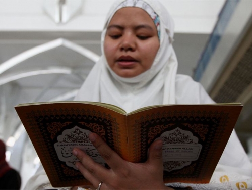 γονεας θυματος διαβαζει το Κορανι σε προσευχη για τα θυματα σε τζαμι της Μαλαισιας