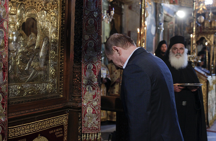 epa05333624 Russian President Vladimir Putin bows in front of an icon of Virgin Mary as he visits the church of the Protaton, dedicated to the Dormition of the Virgin, in Karyes, the administrative centre of the all-male Orthodox monastic community of Mount Athos, Greece, 28 May 2016. EPA/ALEXANDROS AVRAMIDIS / POOL