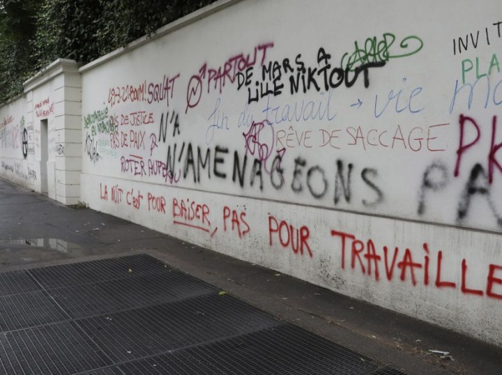 A photo taken June 15, 2016 shows graffiti, spray painted during a demonstration against labour reforms on June 14, covering a wall on Boulevard des Invalides in Paris. / AFP PHOTO / Jacques DEMARTHON